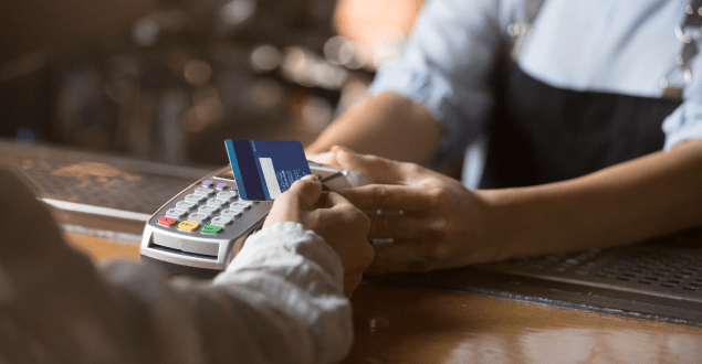 Female-customer-holding-credit-card-near-nfc-technology-on-counter Female customer holding credit card near card reader technology on counter