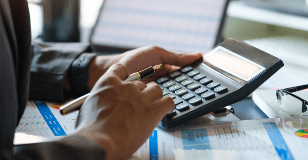 Focused-accountant-working-using-calculator-for-calculating-refinanced-mortgage Focused accountant working using calculator for calculating refinanced mortgage