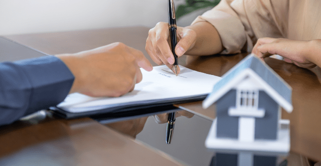Real-estate-agents-and-buyers-signing-a-mortgage-contract Real estate agents and buyers signing a mortgage contract