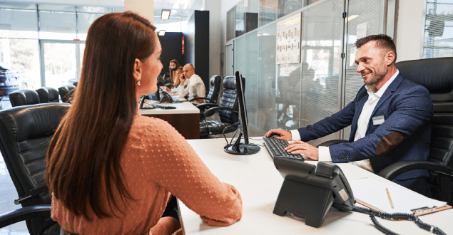 banker-meeting-with-client-at-desk money with digital graph overlay