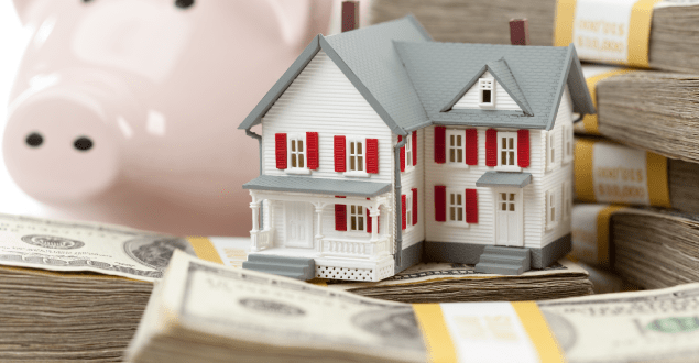 model-house-surrounded-by-money-with-piggy-back-in-background Businessman in suit showing a contract and pointing with a pen where the client must to sign