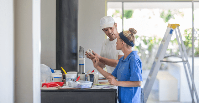 Side-view-of-couple-standing-at-kitchen-counter-looking-at-paint Side view of couple standing at kitchen counter looking at paint