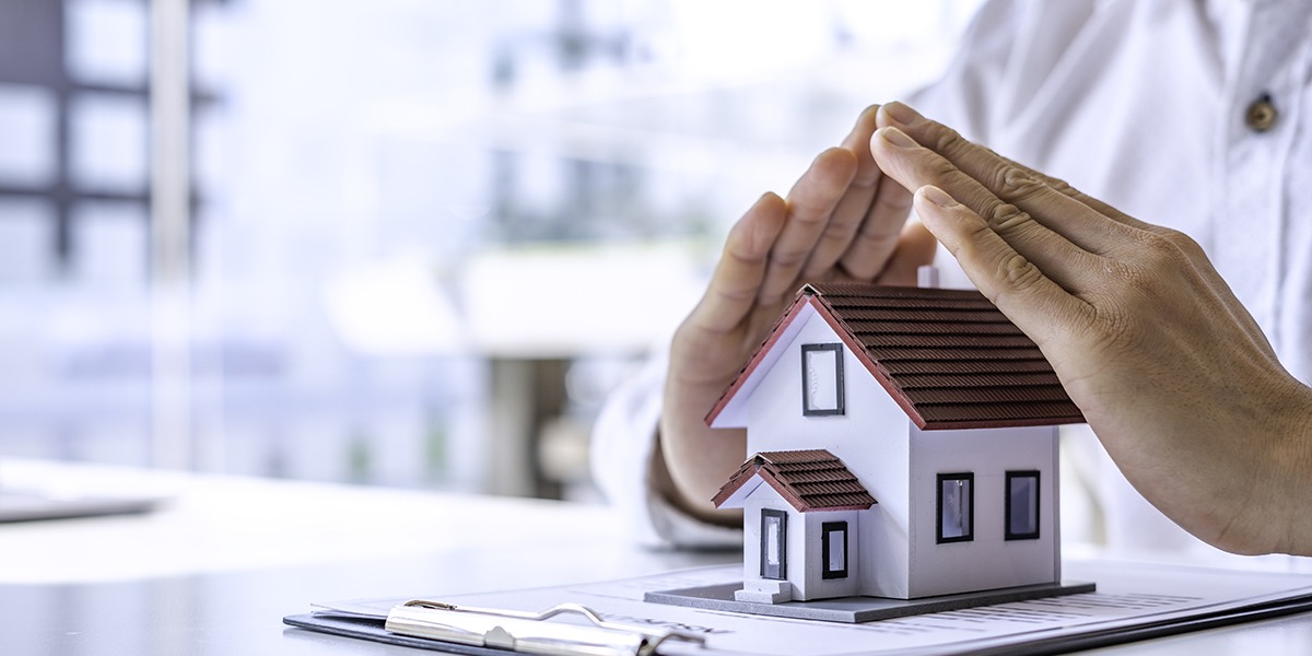 A close-up view of a man defending a home model by hand on a table in an office.